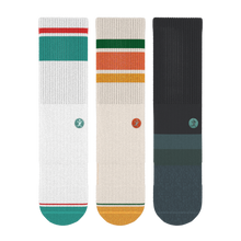 Load image into Gallery viewer, A group of crew socks with a logo, close-up details of the fabric, and a striped towel.