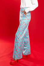 Load image into Gallery viewer, A person in The Peppermint Pimp Canes, candy cane women's suit pants, attracting attention with a unique festive pattern.