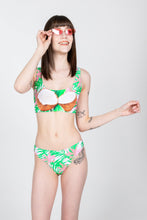 Load image into Gallery viewer, A woman in a tropical coconuts bikini bottom, with a garment featuring coconuts, sunglasses, and tattoos.