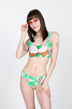 Load image into Gallery viewer, A woman in The Piña Colada | Tropical Coconuts Bikini Bottoms, with a garment, coconut tattoos, and sunglasses.