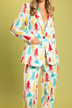 Load image into Gallery viewer, A person wearing The Pine Tree Playgirl pajama suit with retro Christmas trees, a hand in pocket, and colorful patterned leg.
