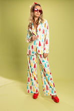 Load image into Gallery viewer, A woman in a retro Christmas tree pajama suit, with a close-up of red sunglasses and a platform shoe.