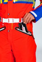 Load image into Gallery viewer, A person in a red jumpsuit putting a phone in their pocket.
