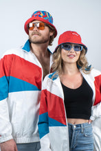 Load image into Gallery viewer, A man and woman in The Chill Out | Reversible Shinesty Bucket Hat, posing with sunglasses and a smile.
