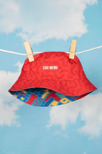 Load image into Gallery viewer, A reversible bucket hat on a clothesline with clothespins.
