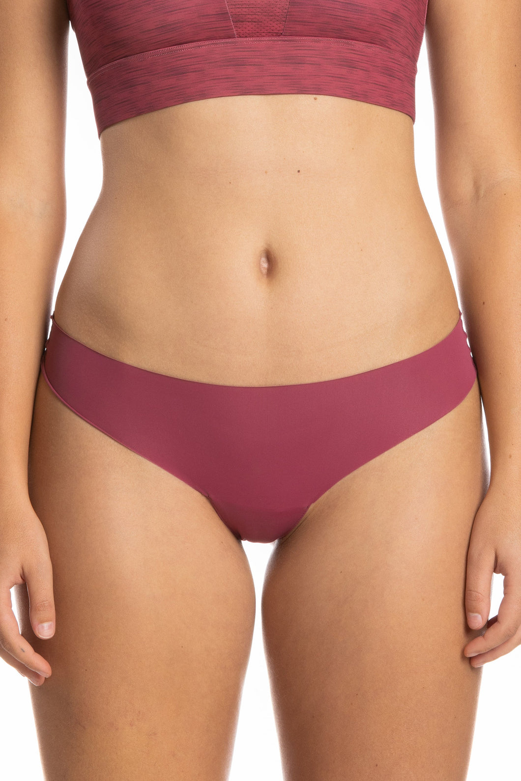 A close-up of The Bordeaux | Mauve Seamless Thong Underwear on a woman's body, showcasing the garment's seamless design and delicate style.