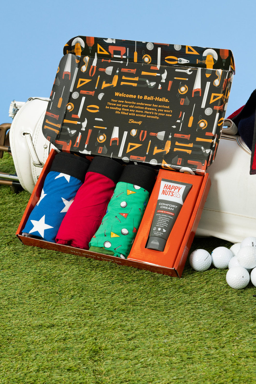 A box of golf items with a variety of underwear and a lotion.