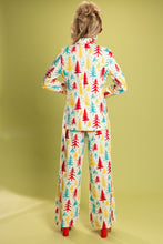 Load image into Gallery viewer, Woman in retro Christmas tree pajamas, standing in a festive design.
