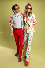 Load image into Gallery viewer, A man and woman in matching outfits, one wearing a white pajama with a colorful tree pattern, the other with brown hair and mustache wearing sunglasses, standing with a pair of brown shoes and a gold chain necklace.
